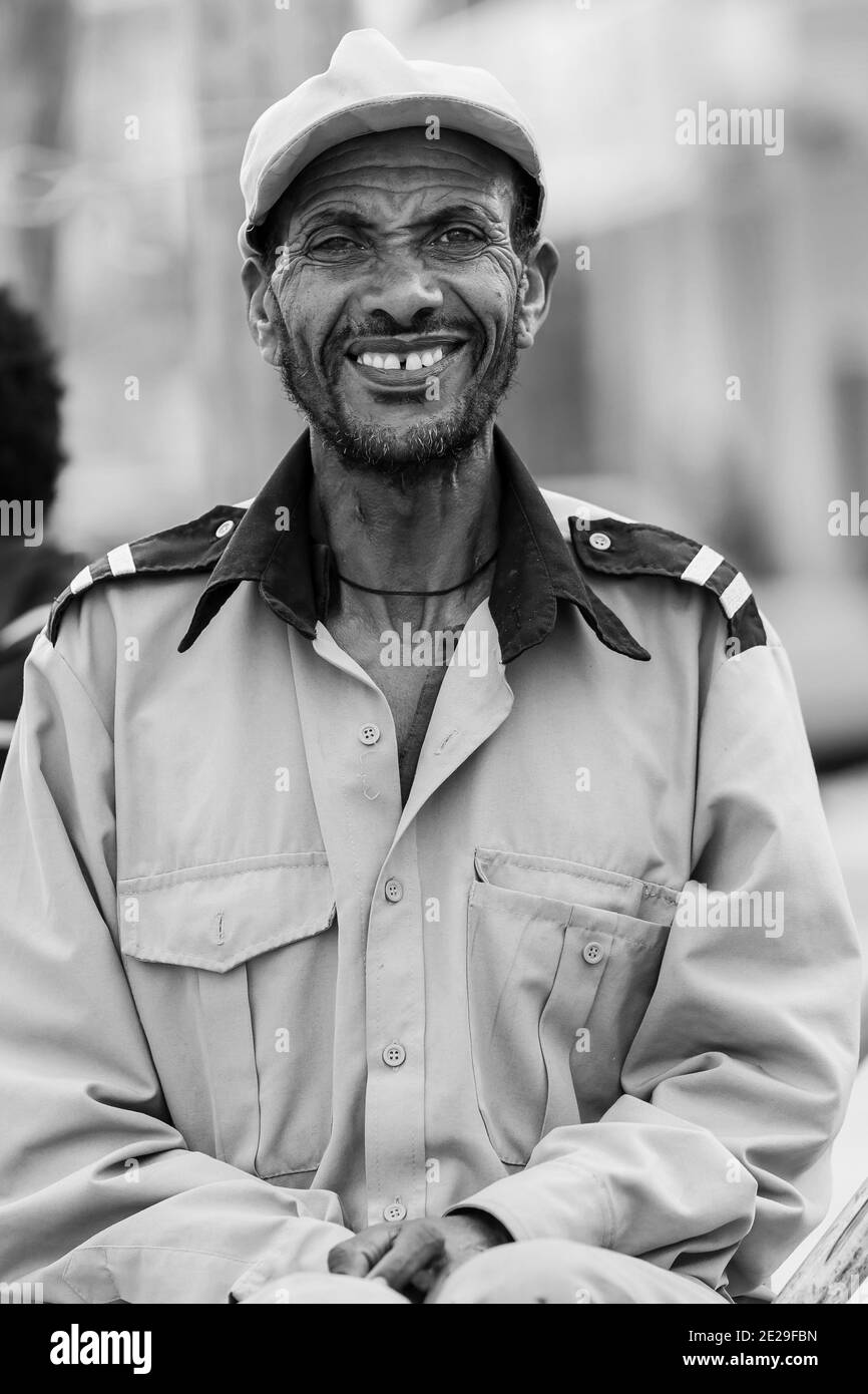 ADDIS ABABA, ETHIOPIA - Jan 05, 2021: Addis Ababa, Ethiopia, January 27, 2014, Happy African man sitting on street corning smiling straight into the c Stock Photo