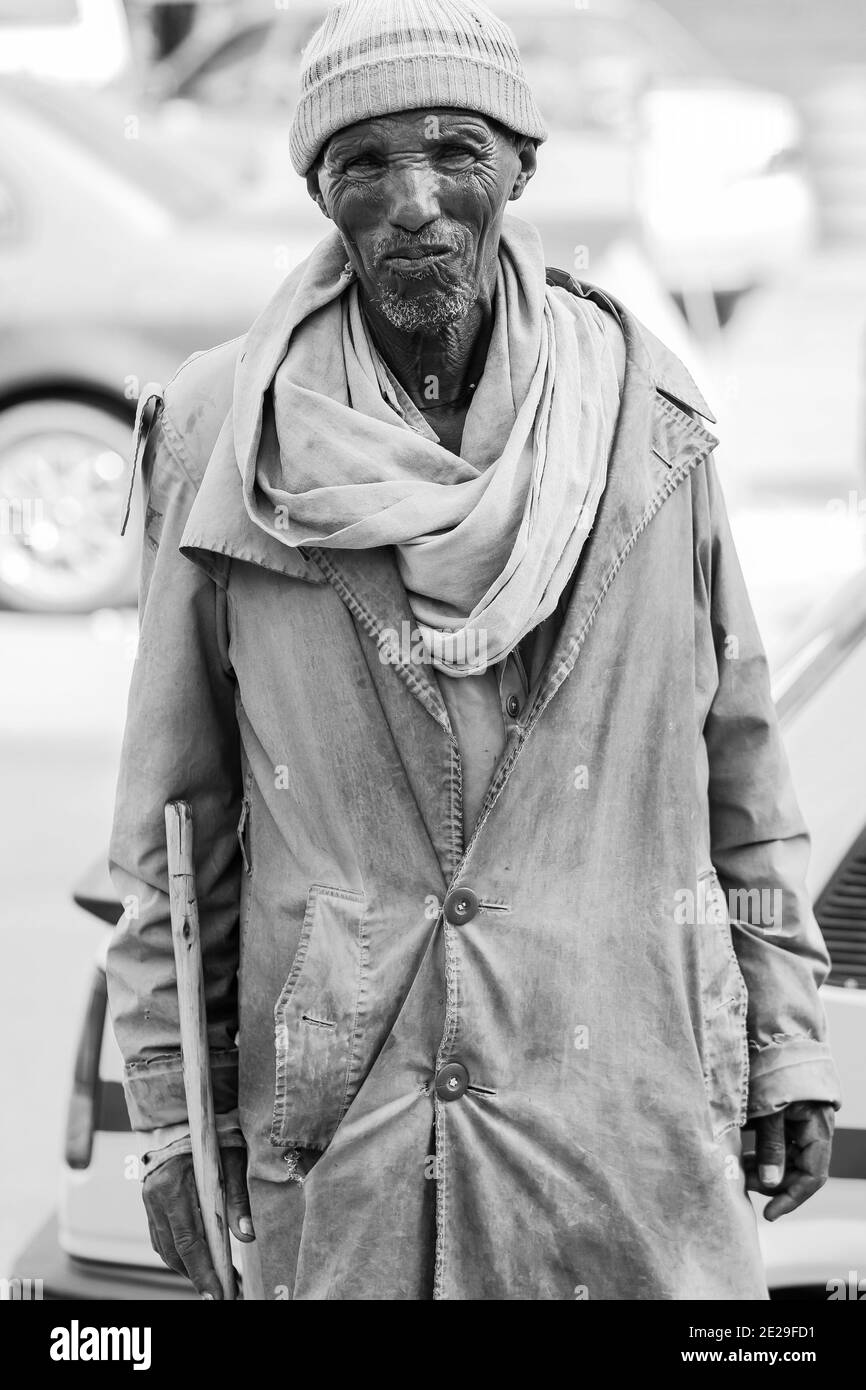 ADDIS ABABA, ETHIOPIA - Jan 05, 2021: Addis Ababa, Ethiopia, January 27, 2014: Old man walking in the streets of city suburb Stock Photo