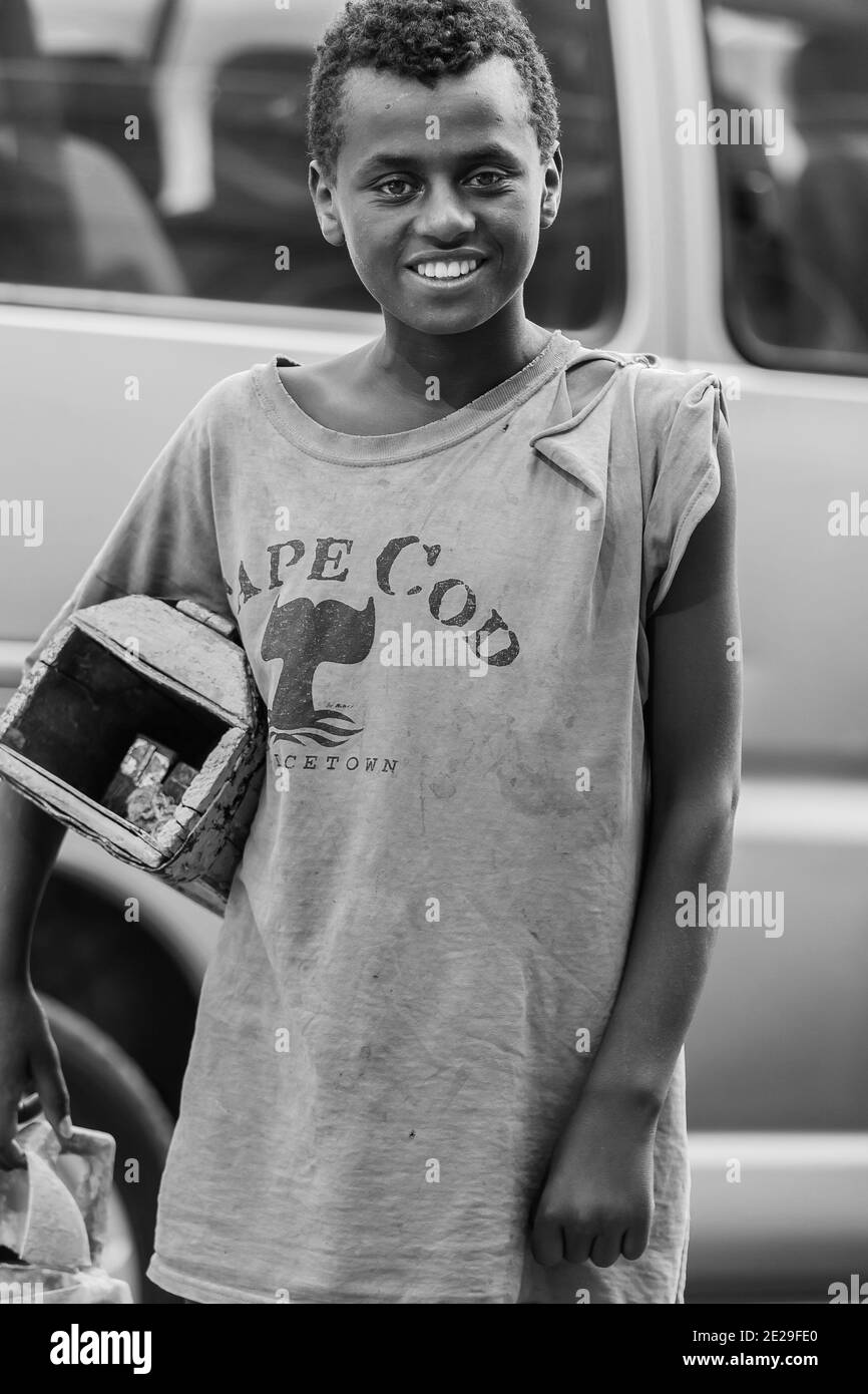 ADDIS ABABA, ETHIOPIA - Jan 05, 2021: Addis Ababa, Ethiopia, January 27, 2014, Young teenager working as a shoe shine boy on the street, looking strai Stock Photo