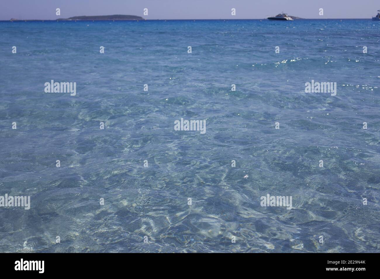 High angle shot of the blue clear sea with a boat sailing on the ...