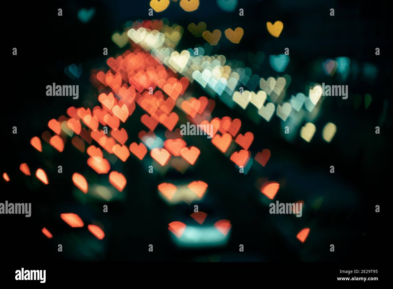 Blurry abstract heart-shaped bokeh from cars in film look Stock Photo
