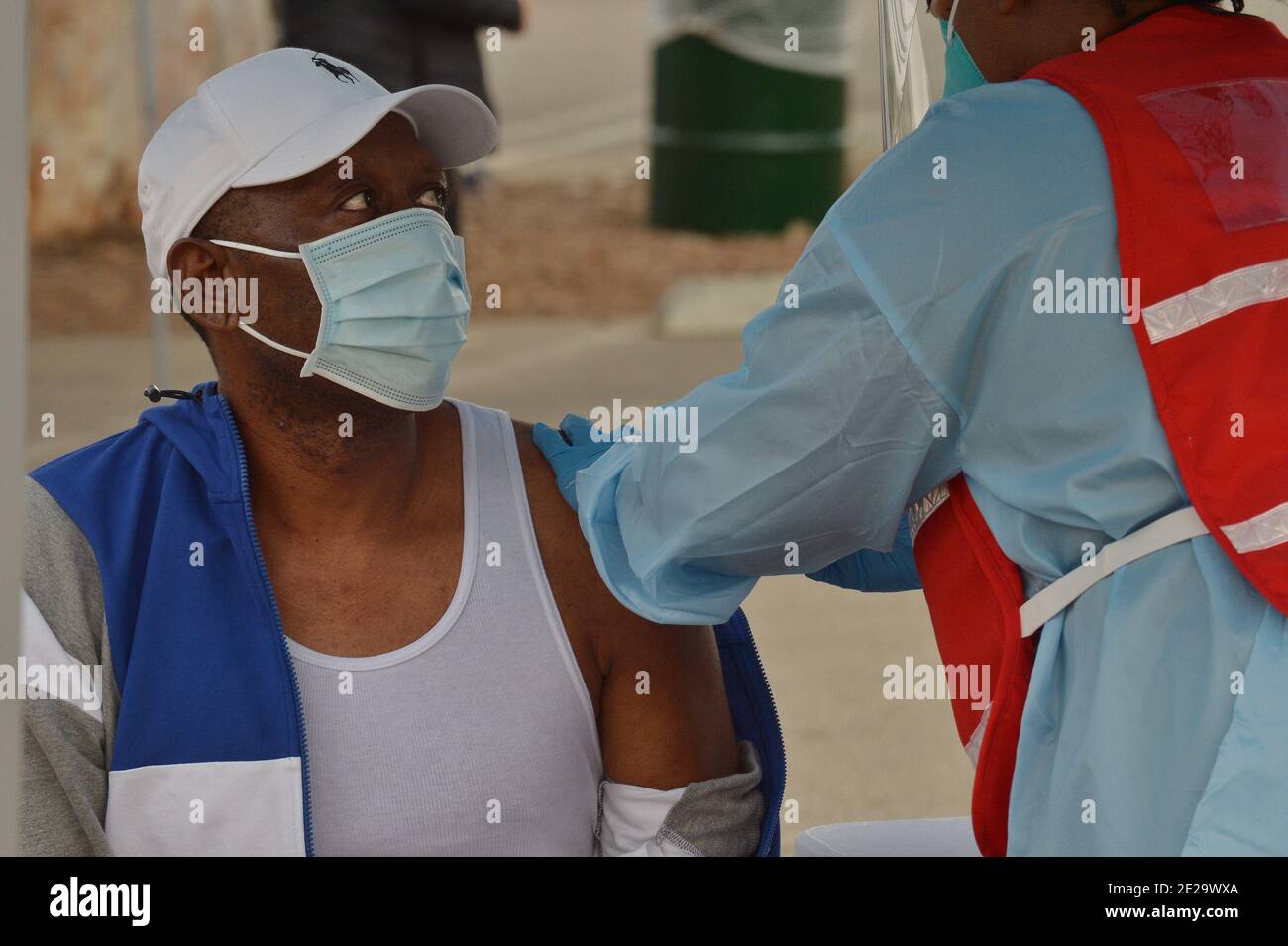 Los Angeles, California, USA. 13th Jan, 2021. A resident is inoculated with the Moderna COVID-19 vaccine at the Balboa Sports Center vaccination site in Los Angeles on Tuesday, January 12, 2021. People aged 65 and older and those with serious.underlying health conditions in Los Angeles and across California could quickly become eligible for a COVID-19 vaccine, with federal officials urging states Tuesday to more widely distribute the shots. Photo by Jim Ruymen/UPI Credit: UPI/Alamy Live News Stock Photo