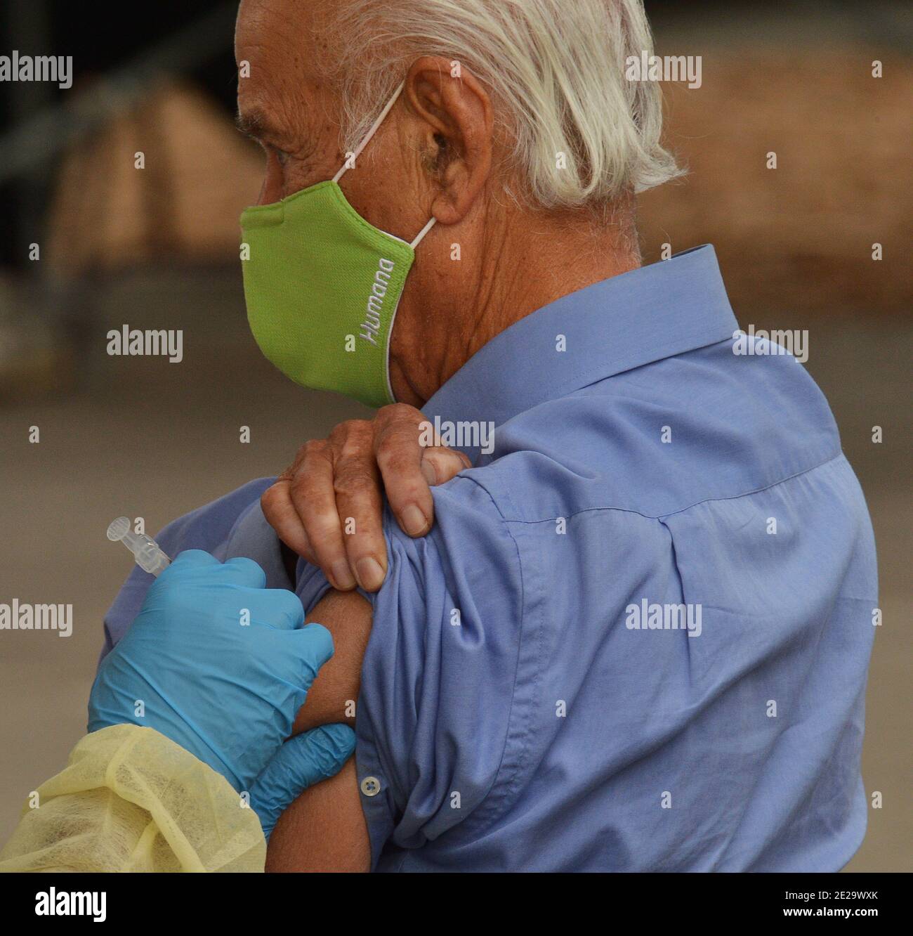 Los Angeles, California, USA. 13th Jan, 2021. A resident is inoculated with the Moderna COVID-19 vaccine at the Balboa Sports Center vaccination site in Los Angeles on Tuesday, January 12, 2021. People aged 65 and older and those with serious.underlying health conditions in Los Angeles and across California could quickly become eligible for a COVID-19 vaccine, with federal officials urging states Tuesday to more widely distribute the shots.  Photo by Jim Ruymen/UPI Credit: UPI/Alamy Live News Stock Photo