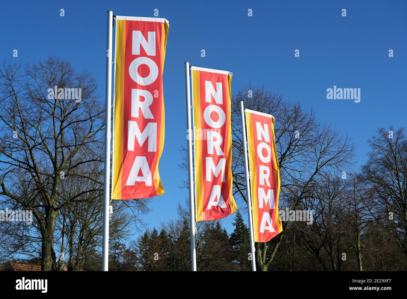 Ratzeburg, Germany, January 12, 2021: Advertising flags with the logo of the supermarket Norma against a blue sky, widespread food discounter with sto Stock Photo