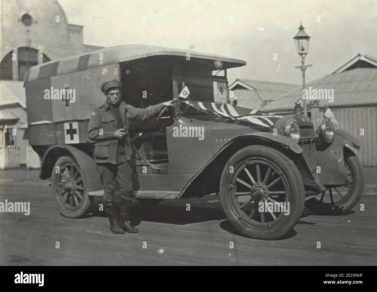 Vintage photograph from the first world war showing red cross ambulance and the driver. Stock Photo