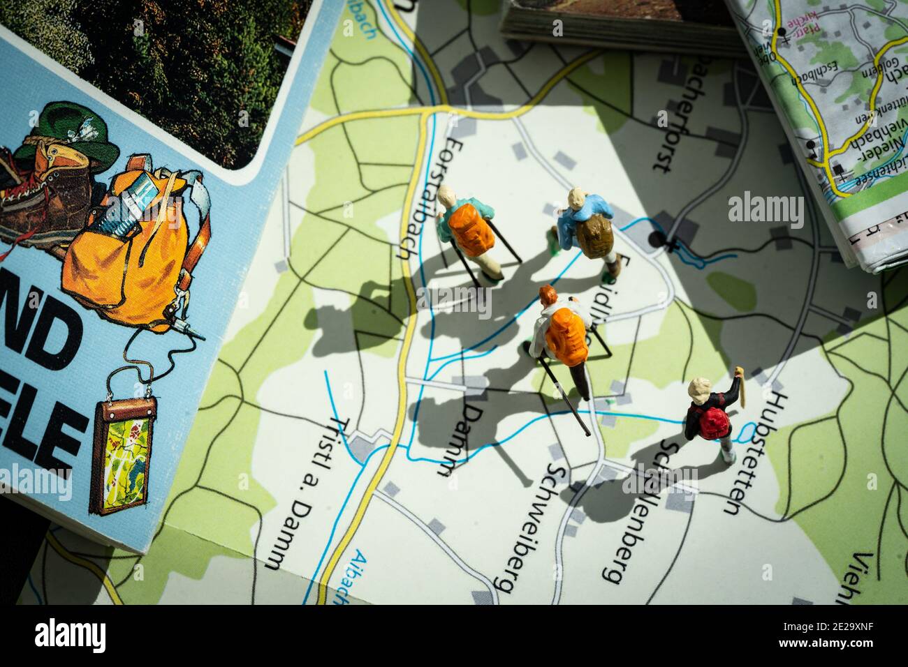 Figurines of backpackers walking over a landscape of trail maps Stock ...