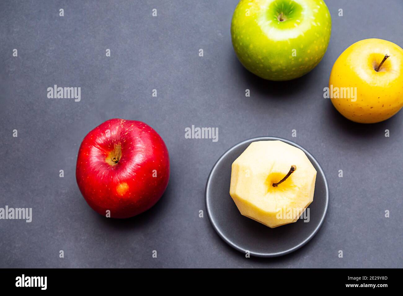 https://c8.alamy.com/comp/2E29Y8D/apples-green-yellow-red-and-apple-without-peel-on-a-black-background-healthy-food-concept-with-copy-space-2E29Y8D.jpg