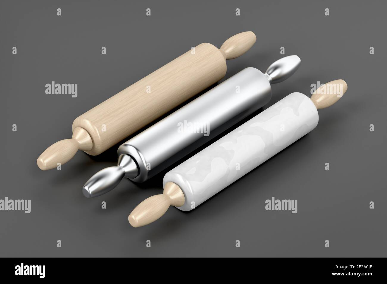 Three rolling pins from different materials on grey background Stock Photo