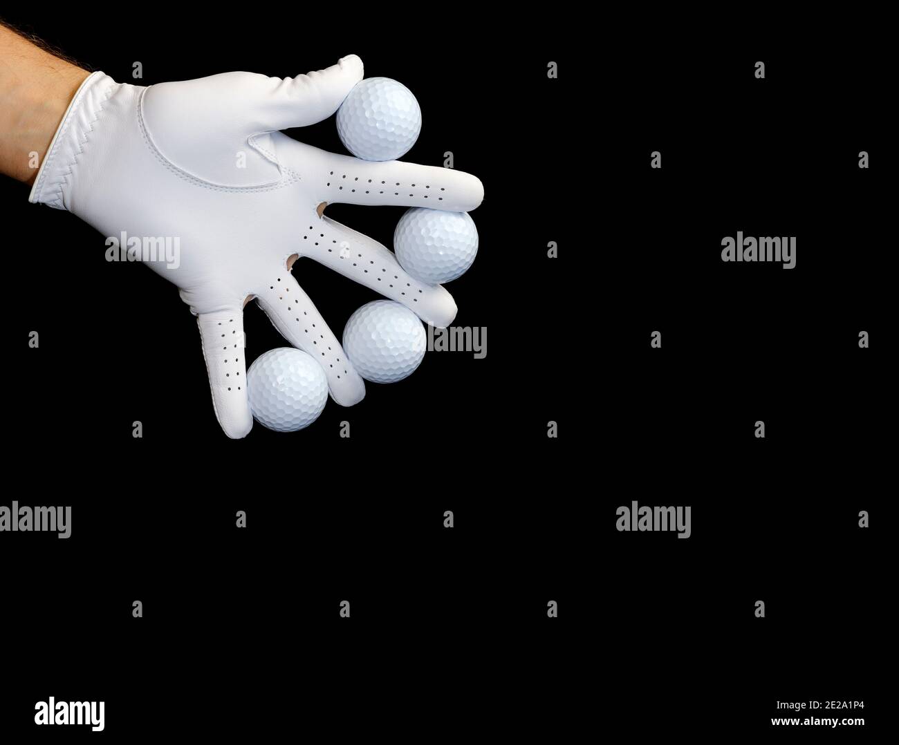 Player wearing a golf glove holding some golf balls between his fingers