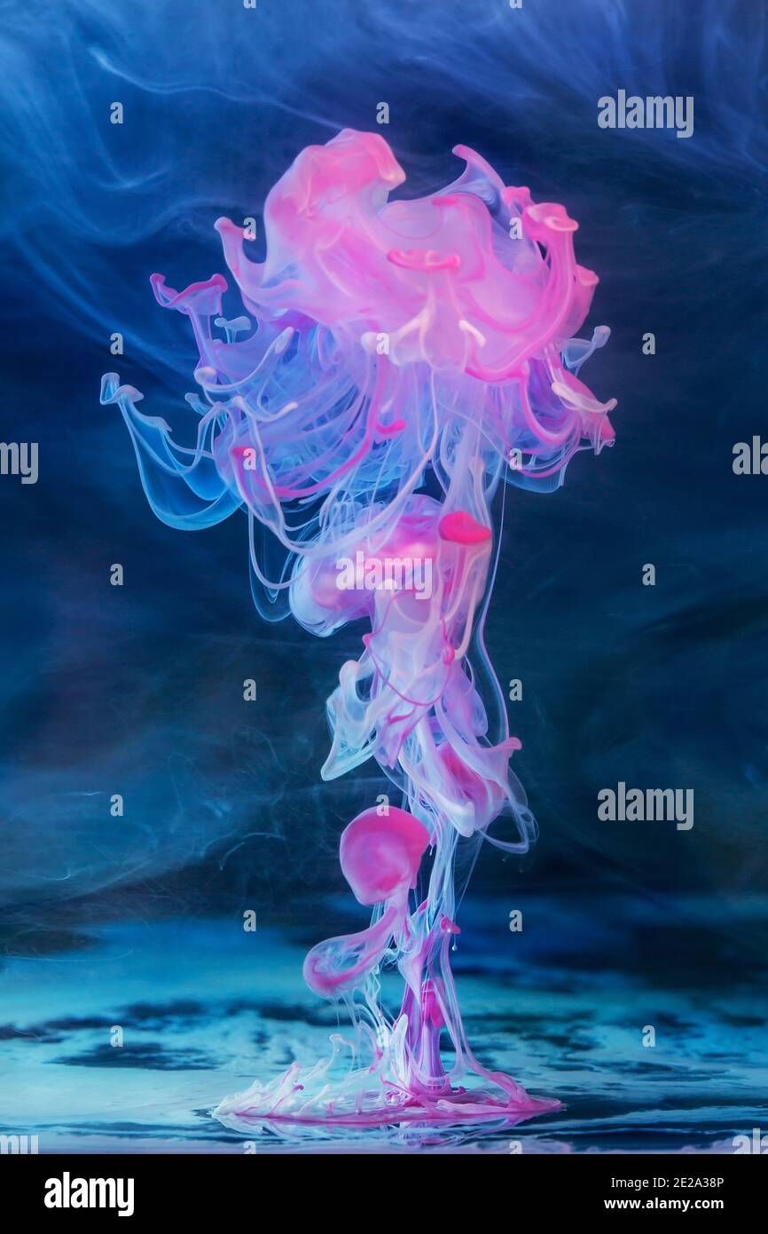 Colored inks in water on blue background Stock Photo