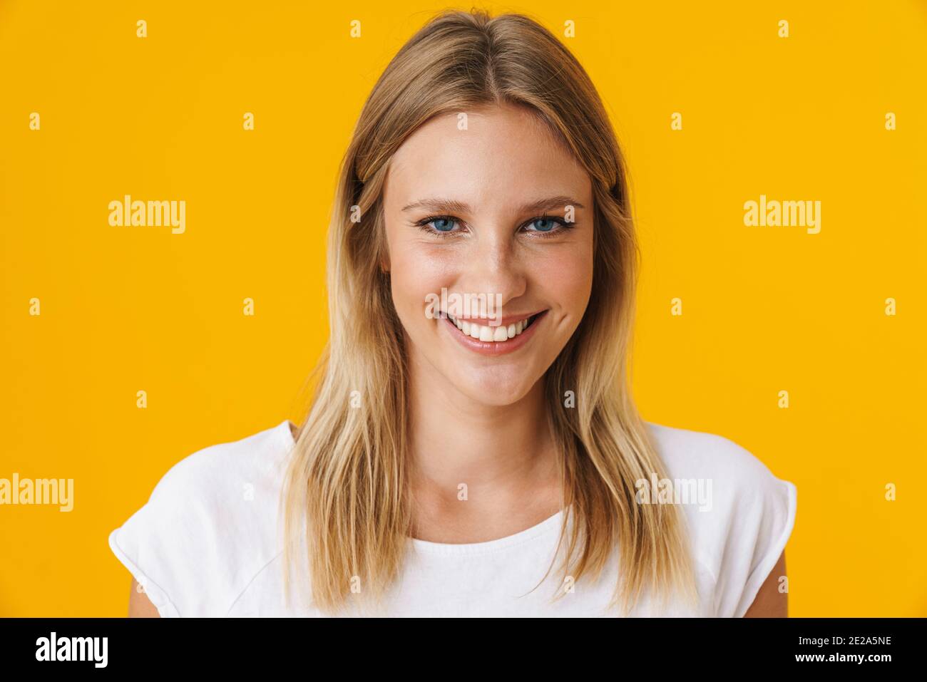 Cheerful beautiful girl smiling and looking at camera isolated over ...