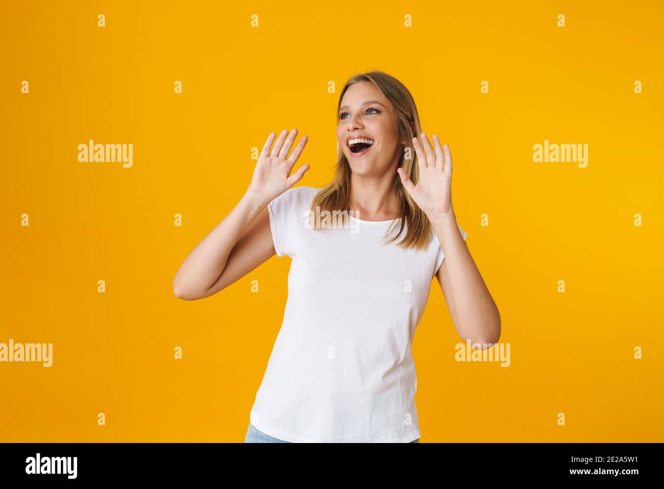 Excited beautiful girl expressing surprise with hands up isolated over ...