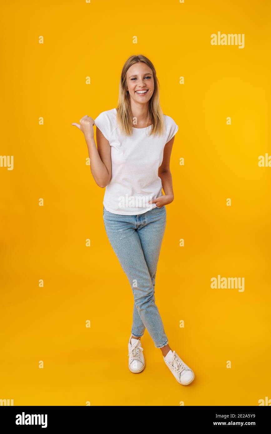 Cheerful beautiful girl smiling while pointing finger aside isolated ...