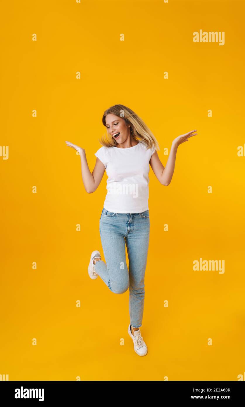 Delighted beautiful girl smiling while showing copyspace isolated over ...