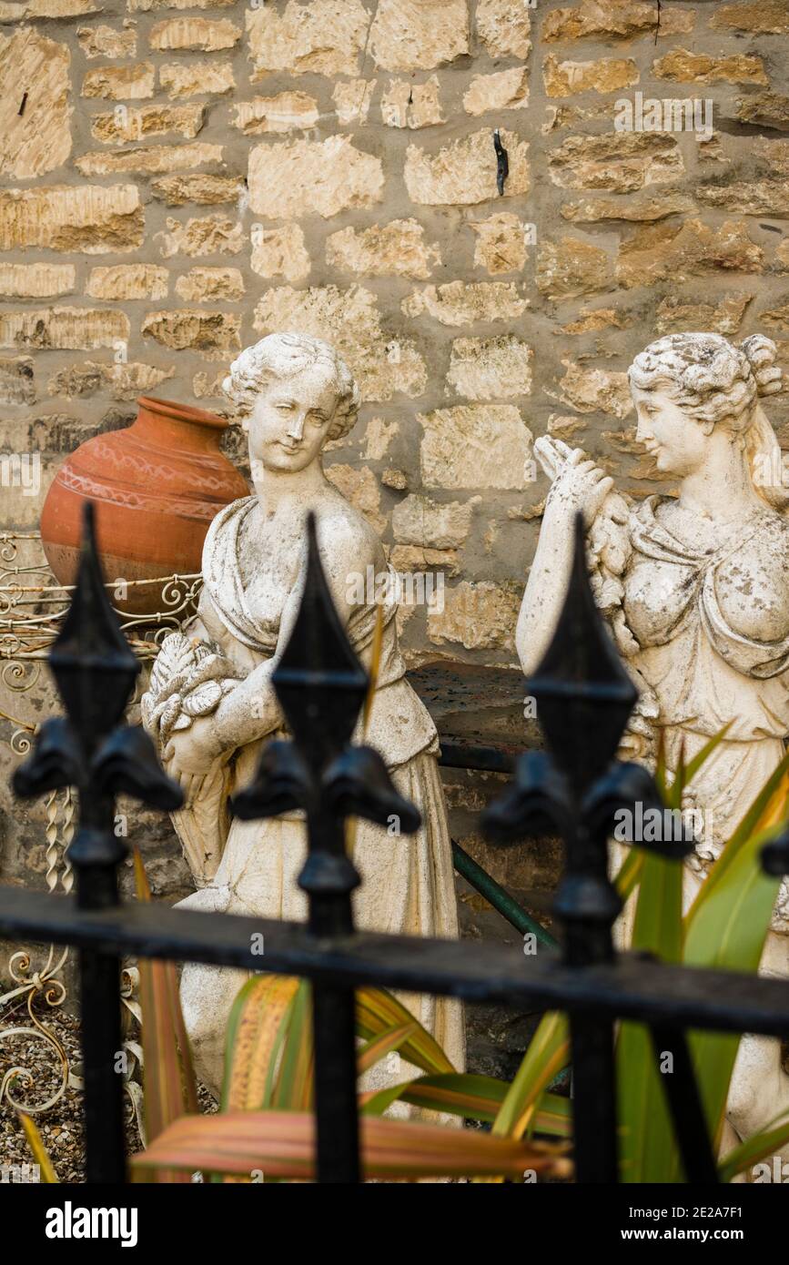 Ornamental garden figurines displayed outside of antique shop, Tetbury, Gloucestershire, UK Stock Photo