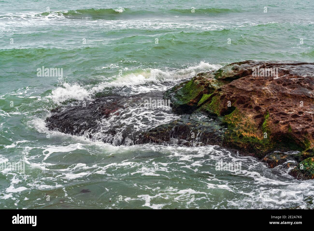 Wave splashing at the rocks, freshness on beach Stock Photo - Alamy