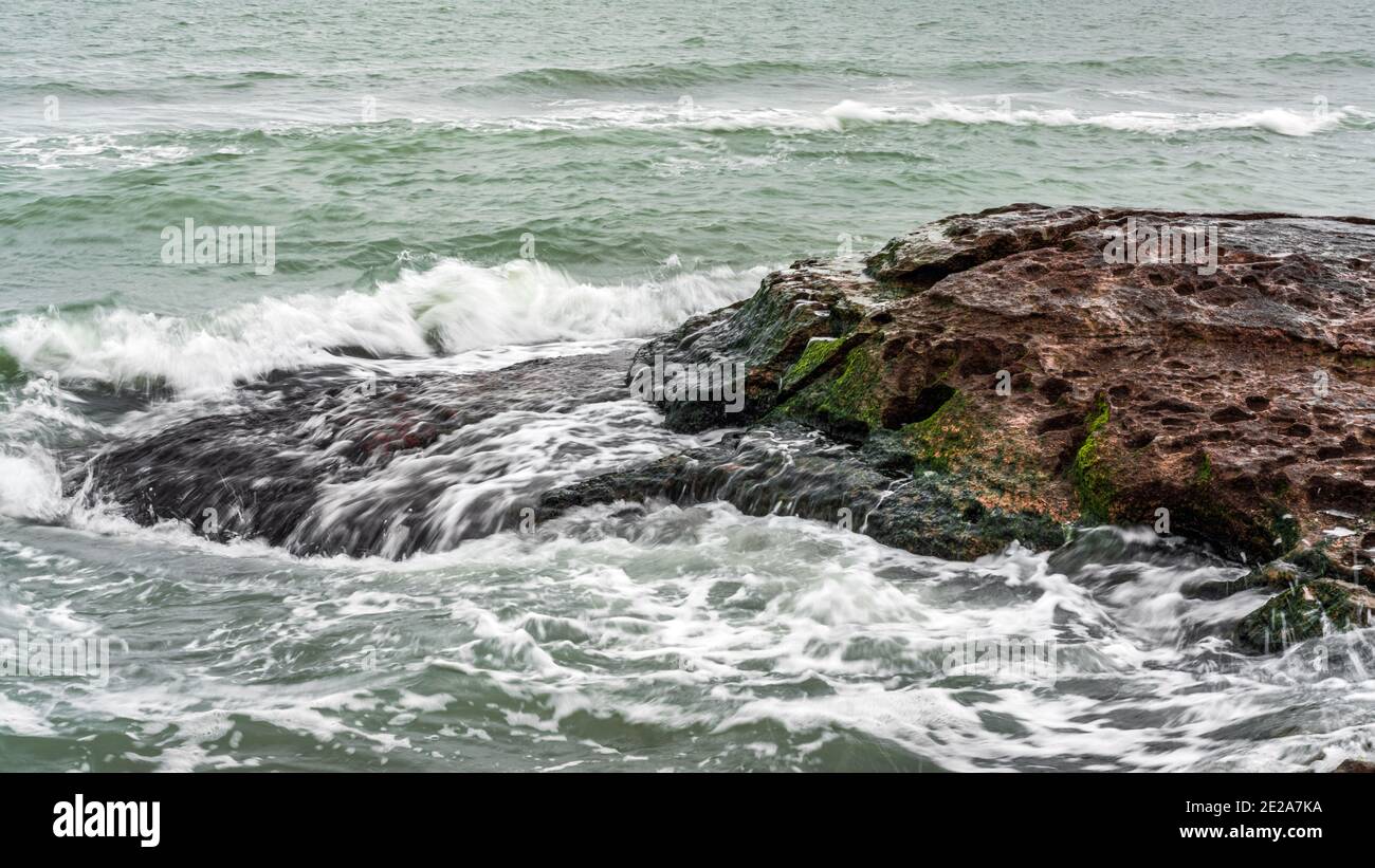 Wave splashing at the rocks, freshness on beach Stock Photo - Alamy
