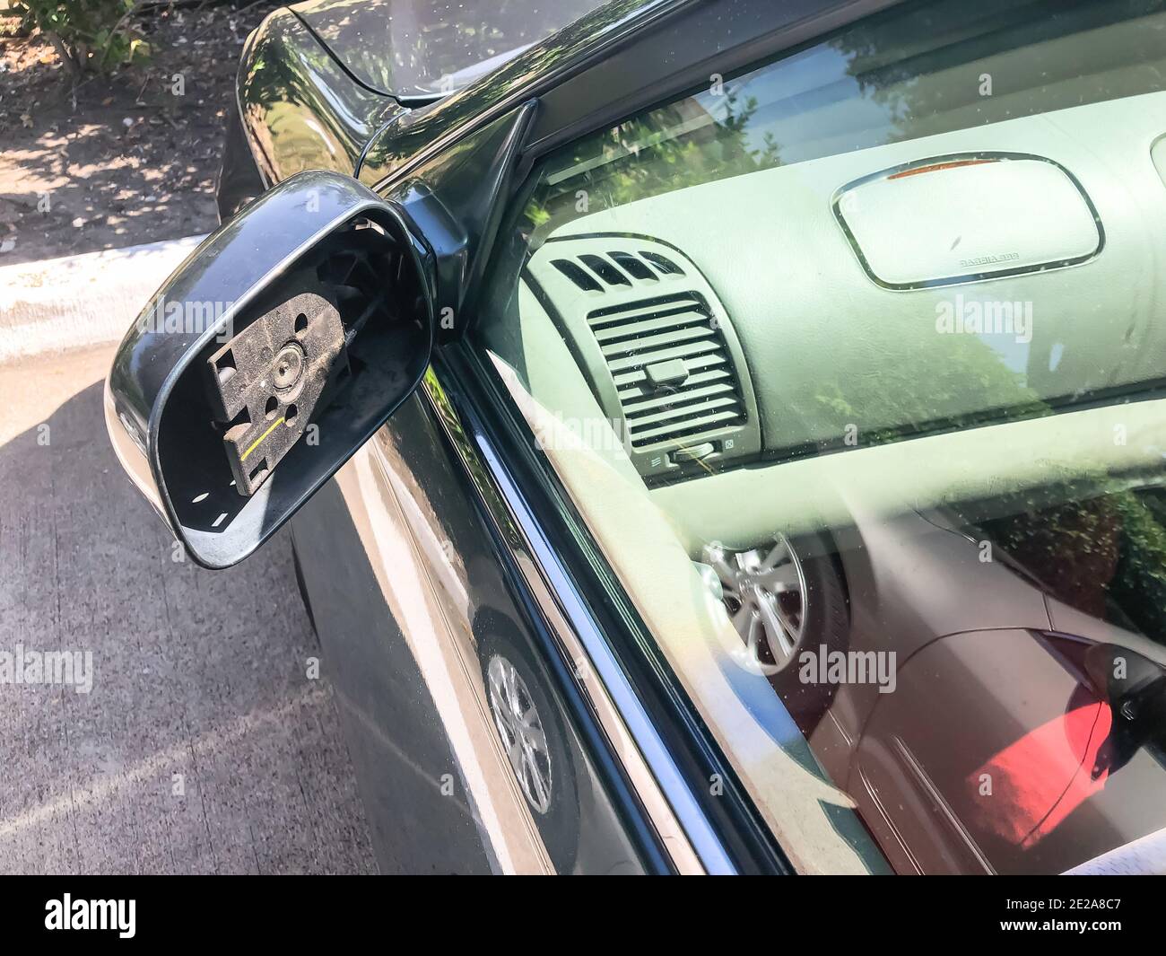 Top view damaged side mirror on green car parked in outdoor parking lot