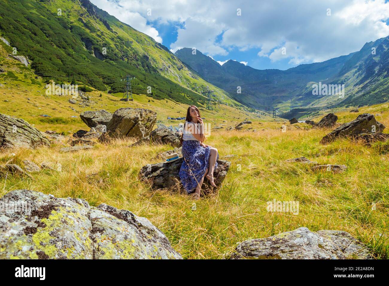 girl in long blue dress sits on a rock in the mountains Stock Photo - Alamy