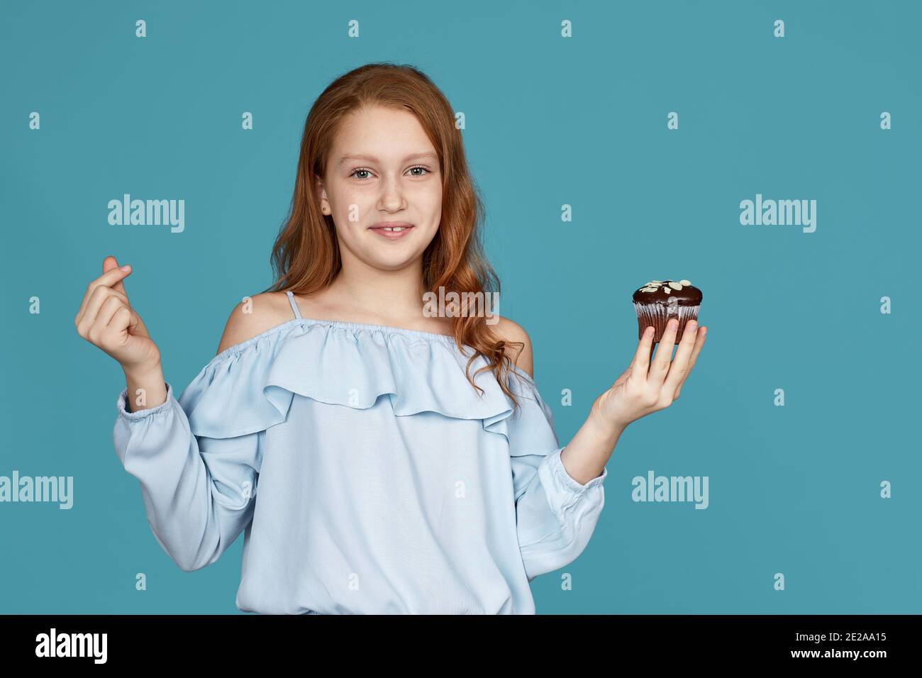 portrait of cute smiling child girl holding in hand cake isolated over ...