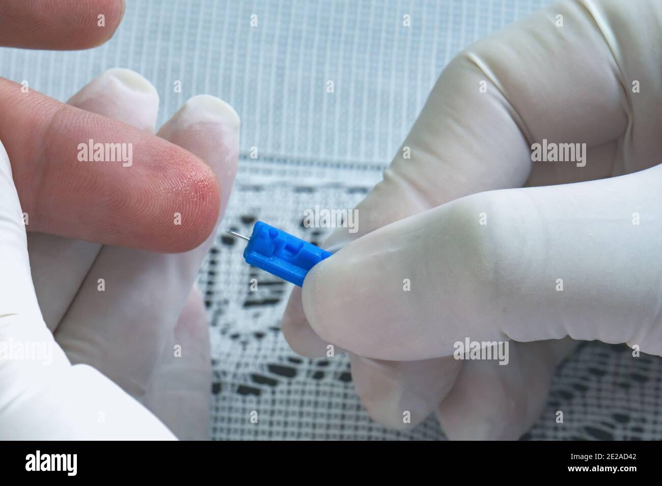 Doctor pricks the finger of a man with a needle to take analysis to ...