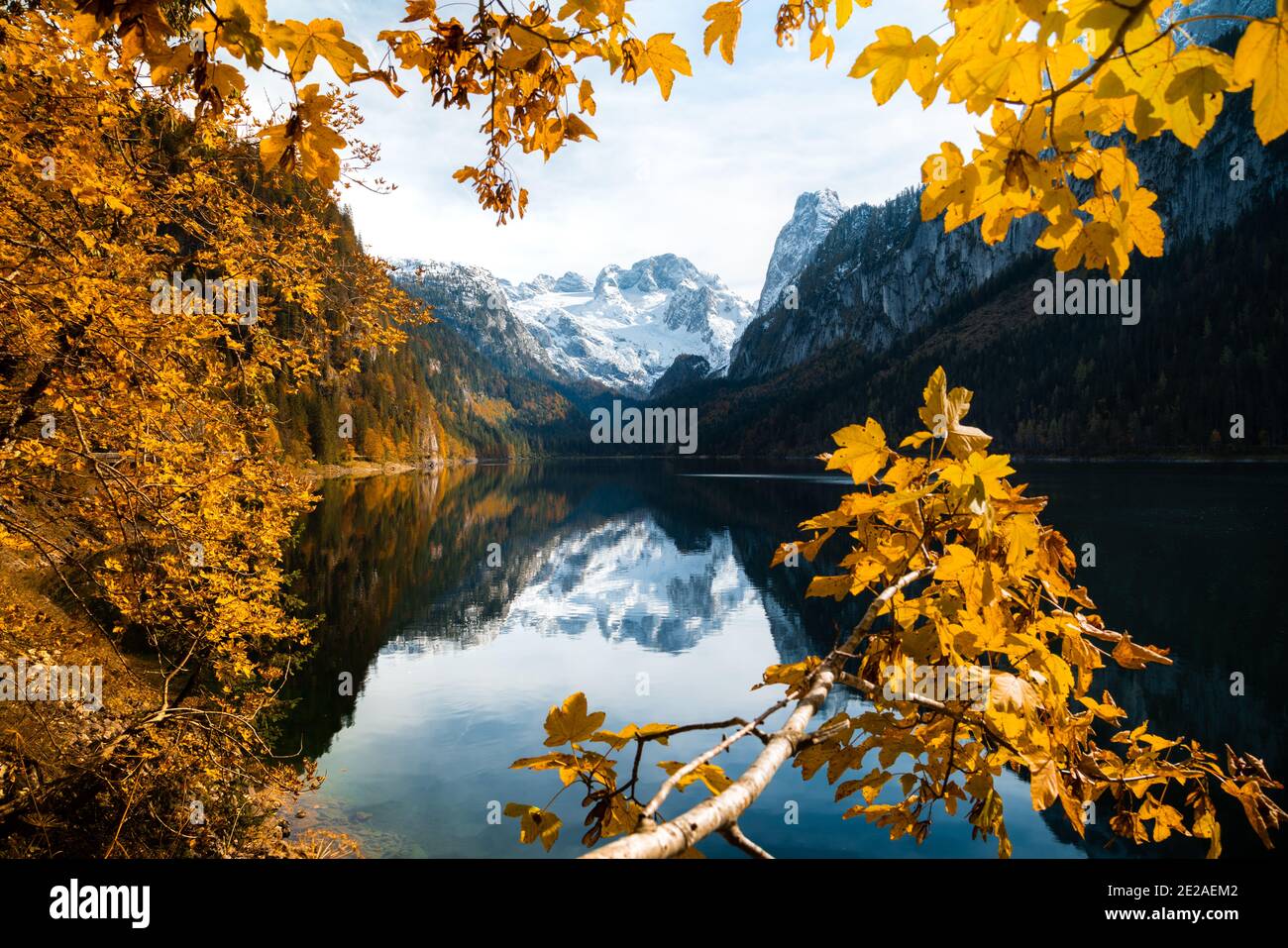Idyllic mountain landscape in the Alps with Dachstein mountain range reflecting in clear Gosausee lake in autumn, Salzkammergut, Austria Stock Photo