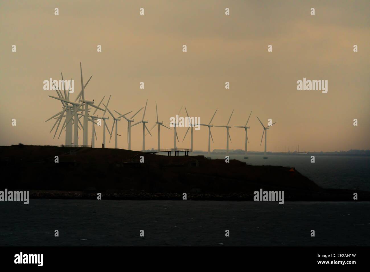 Massive offshore wind turbines generating clean green energy from ocean winds. Stock Photo
