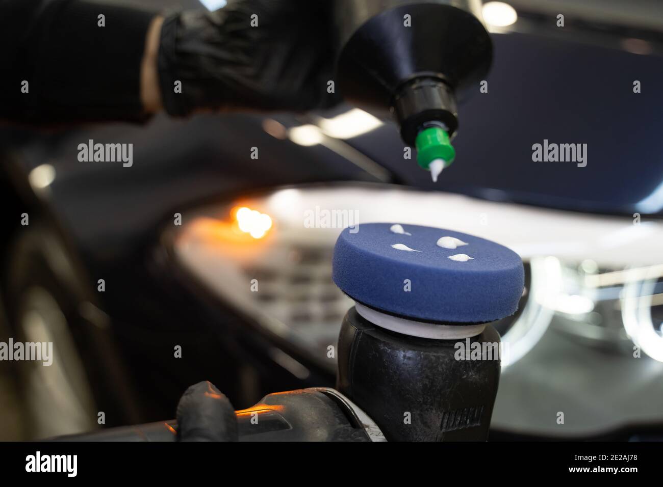 Detailing master applies car polish paste to the polisher. Vehicle paintwork polishing concept Stock Photo