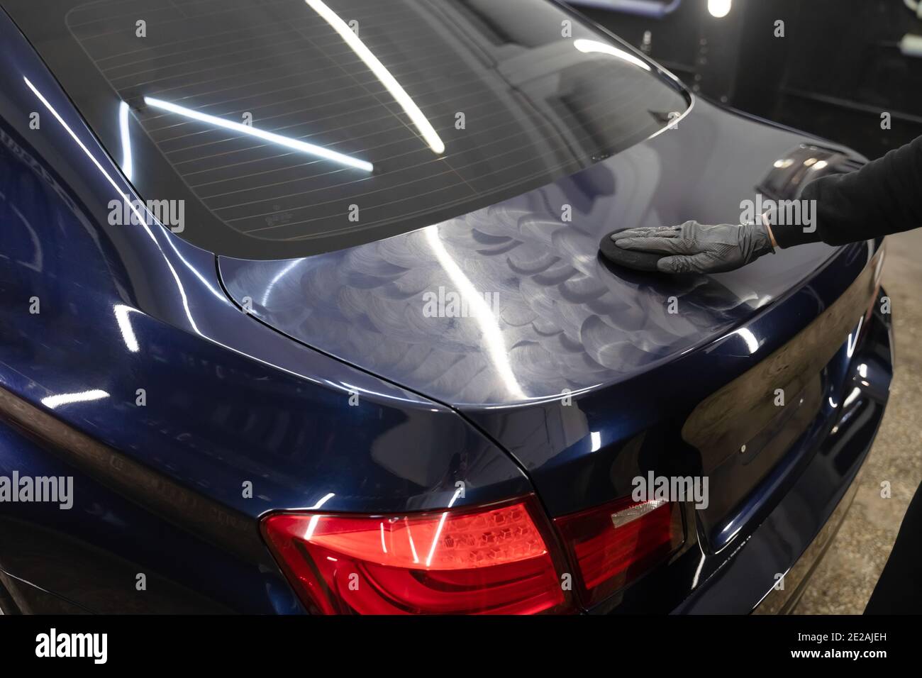 Detailing master applies polishing wax to the car body. Auto detailing concept Stock Photo