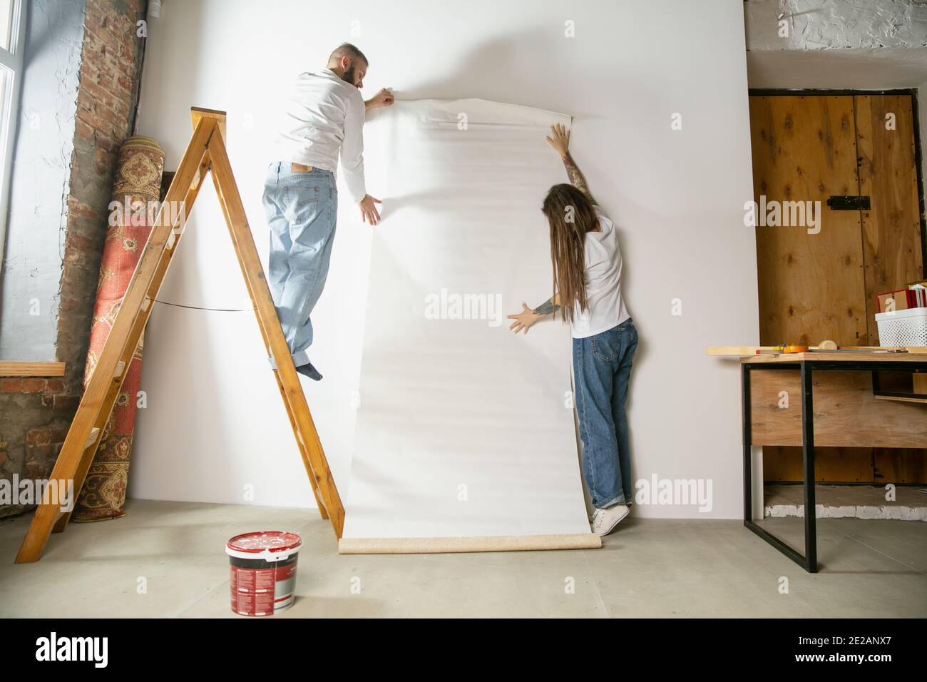 Woman hanging wallpaper hi-res stock photography and images - Alamy