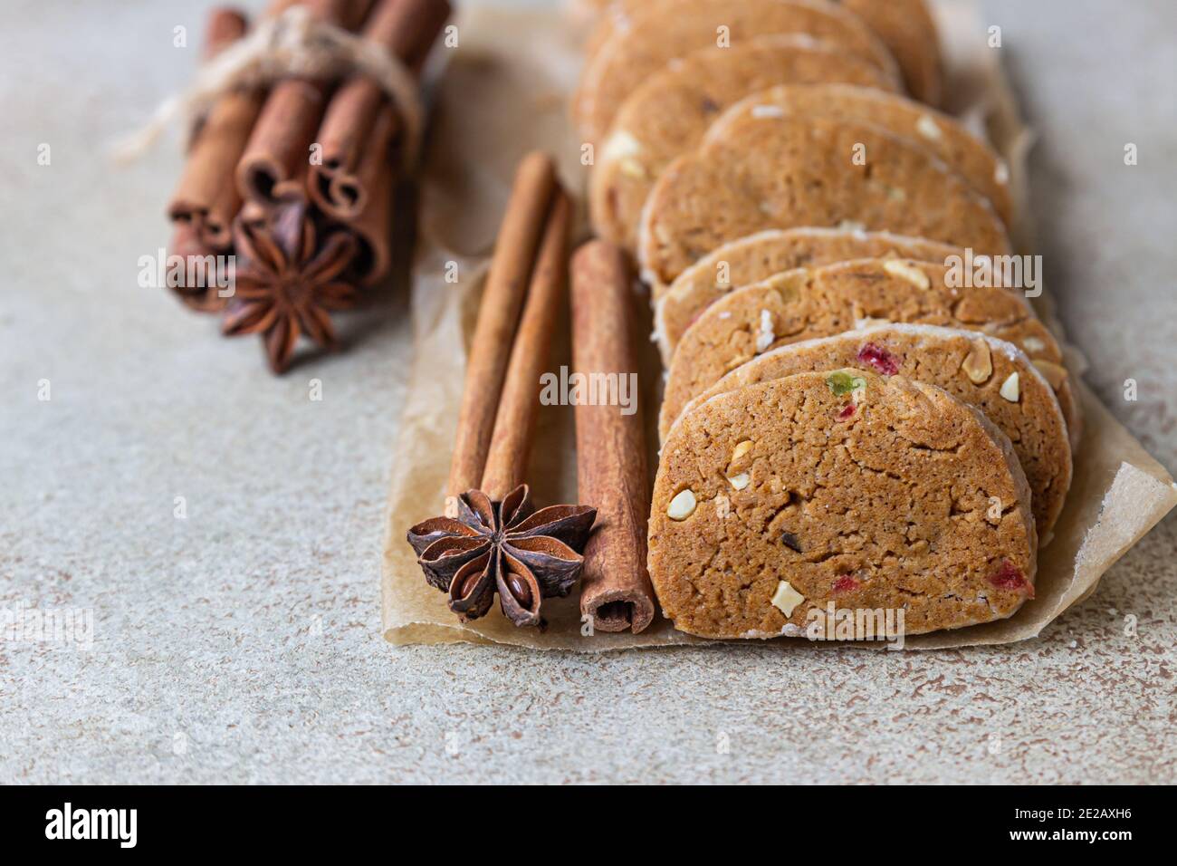Danish spicy butter cookies with candied fruits, cinnamon sticks and anise, light concrete background. Selective focus. Stock Photo