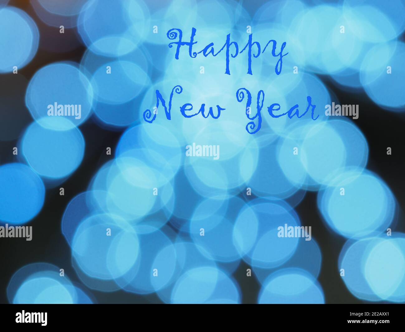 Happy New Year, blue inscription on unfocused bokeh backdrop, dominant blue bubbles in the black background. Greeting card with text. Festive design. Stock Photo