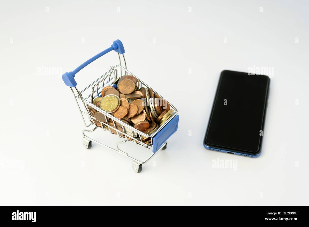 Shopping cart full of coins with a smart phone.Money and financial