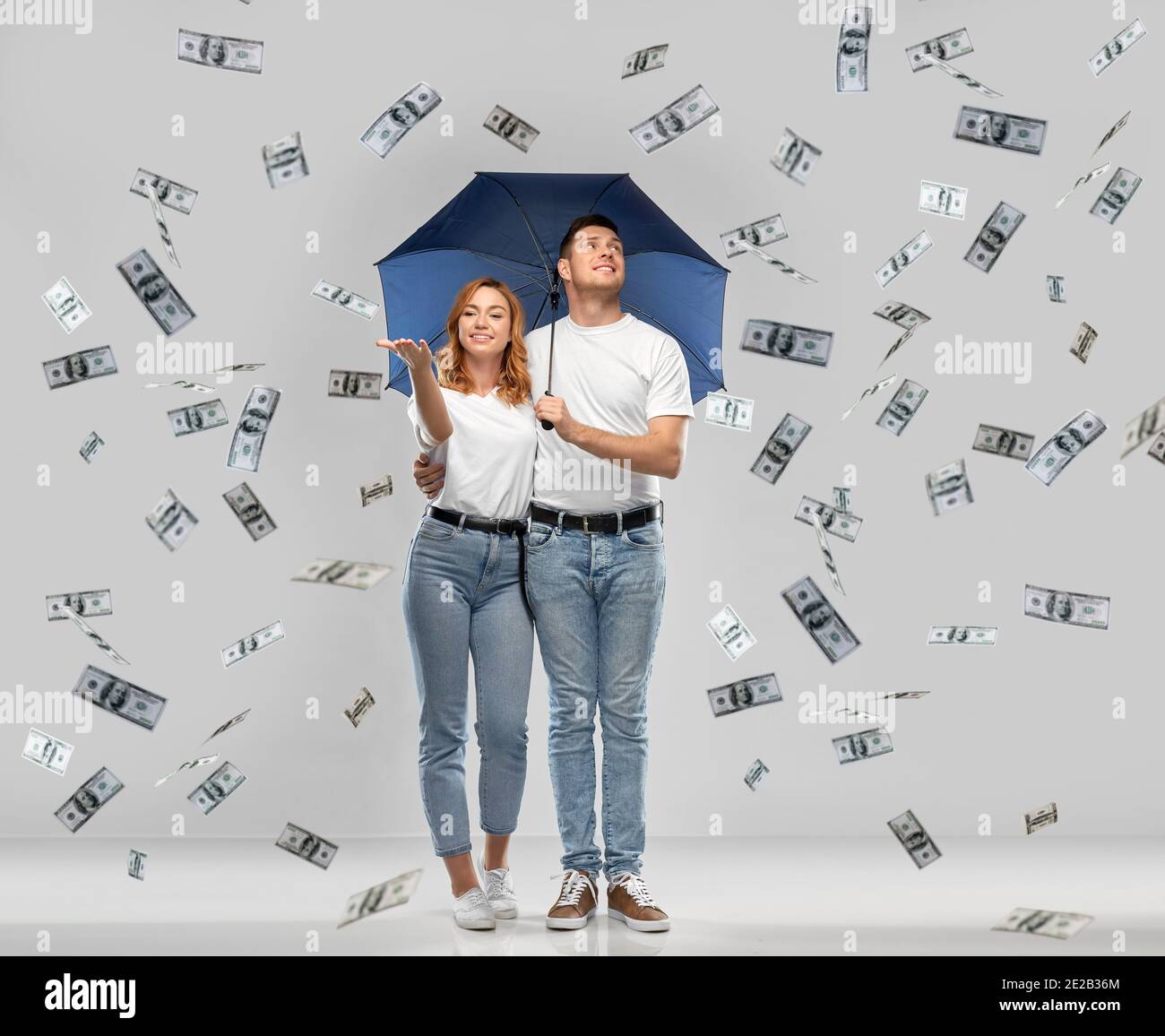 happy couple with umbrella standing money rain Stock Photo