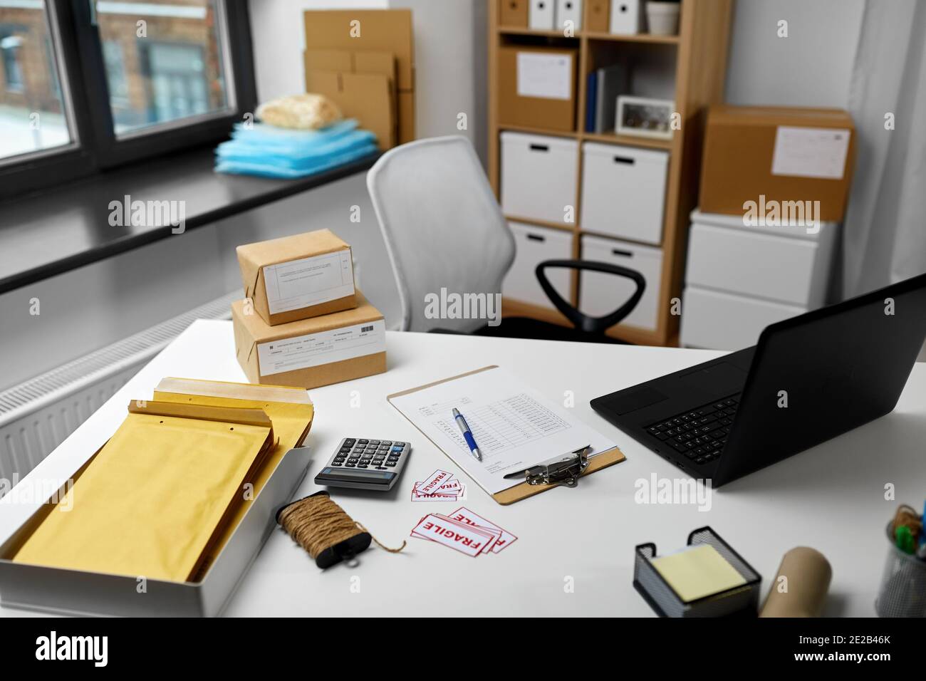 laptop and parcels on table at post office Stock Photo