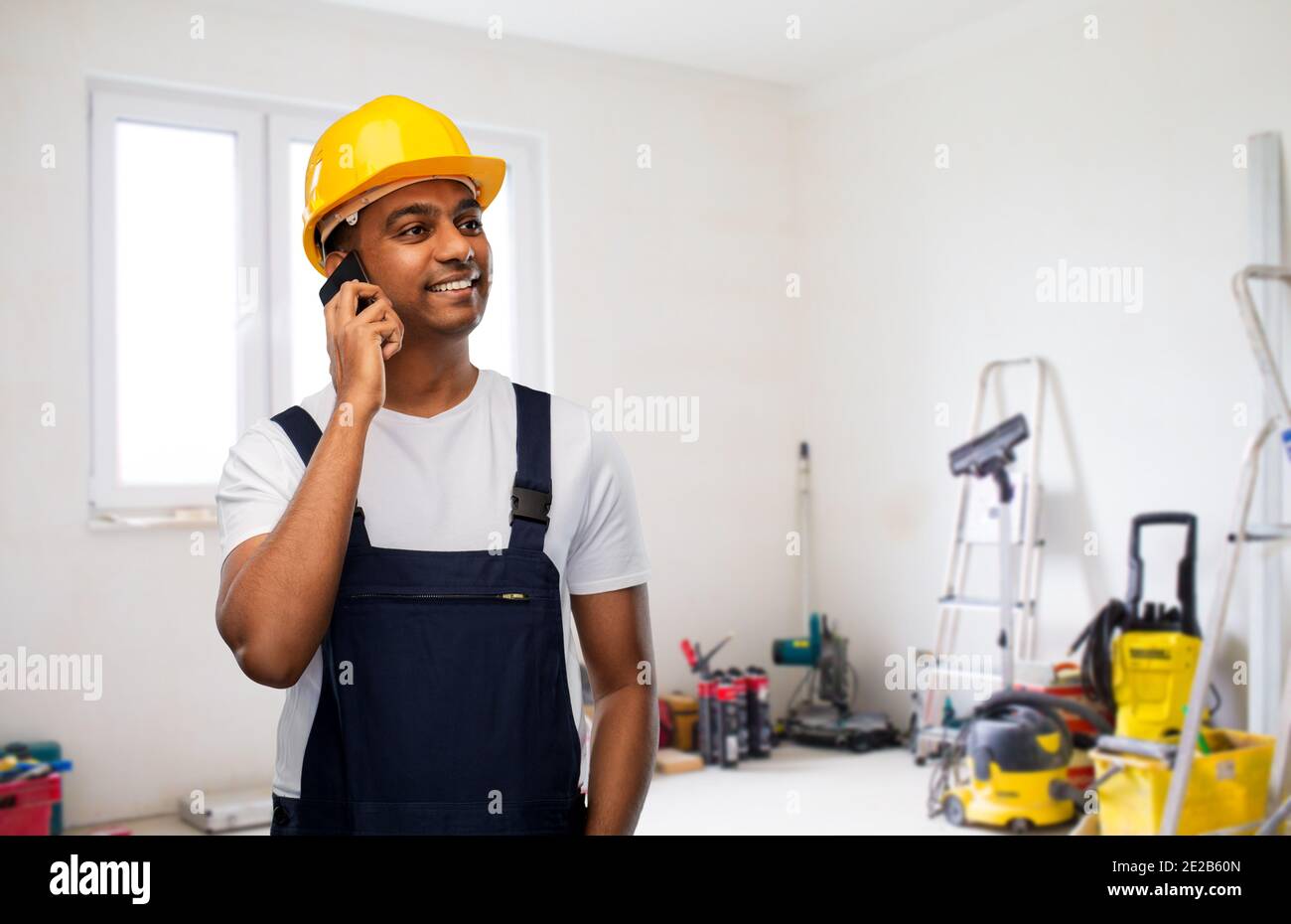 indian builder in helmet calling on smartphone Stock Photo