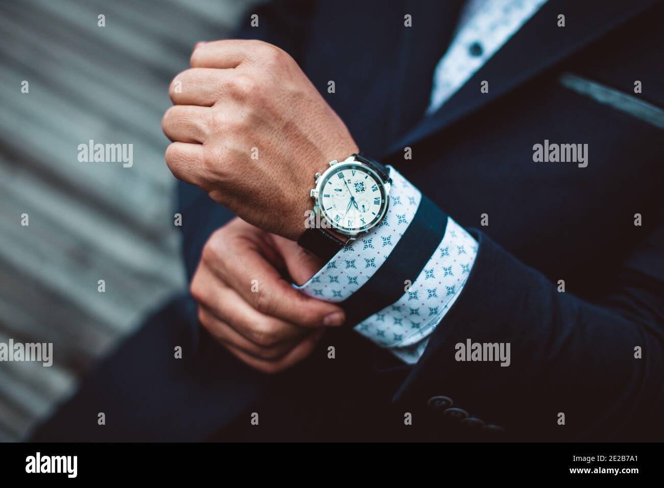 Business man wearing watch on hand and adjusts his shirt Stock Photo Alamy