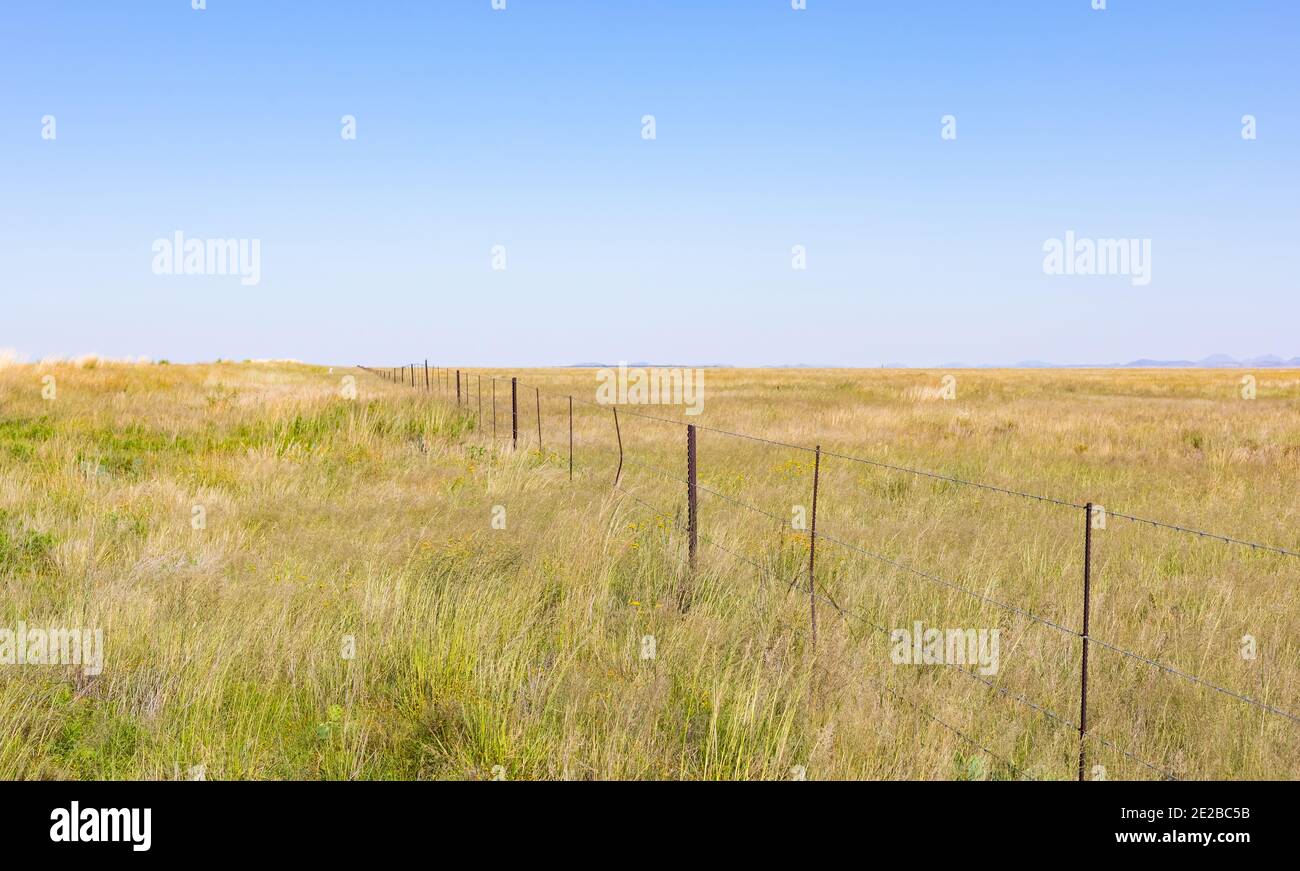 Fence in grassland under the plain blue sky Stock Photo - Alamy