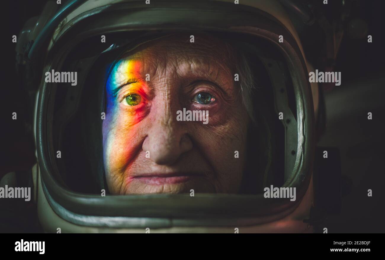 Cinematic portrait of an old astronaut coming back home. Grandmother with vintage space suit. Fiction concept about space exploration and science Stock Photo