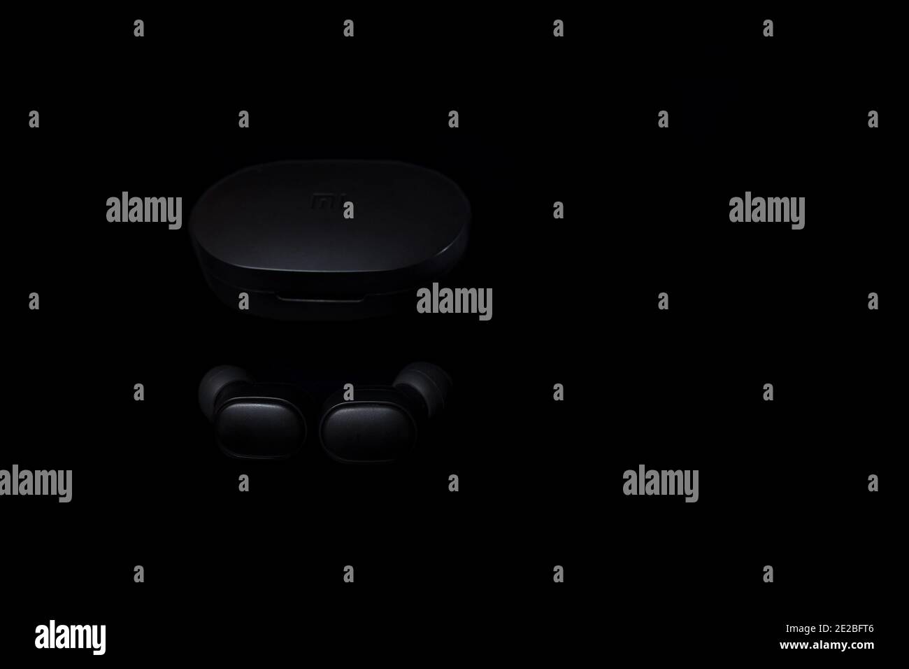 Black Airdots from Xiaomi with charging case isolated on a black with copyspace. Stock Photo