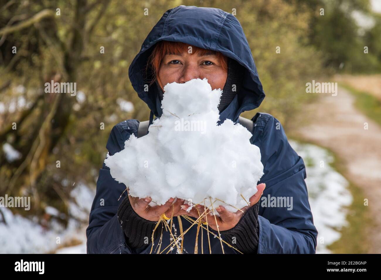 The Thai lady with the red hair with snow in her hands in winter in Aachen  Germany Europe Stock Photo