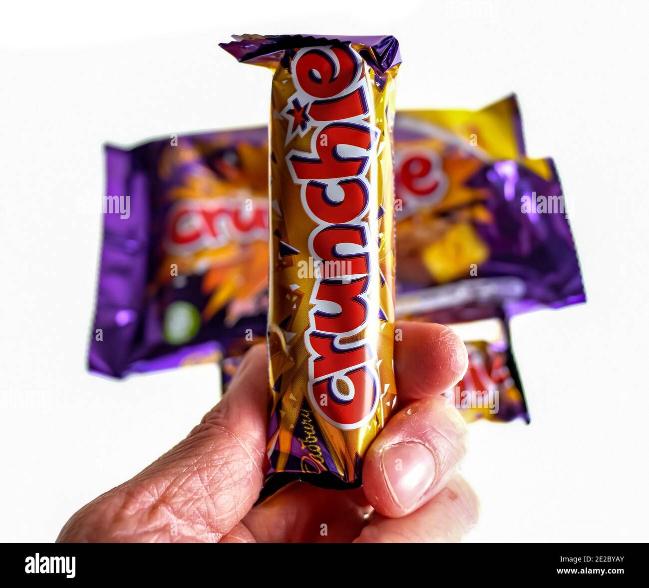 Norwich, Norfolk, UK – December 24 2020. An illustrative editorial photo of an unidentifiable human holding a Cadbury Crunchie chocolate bar Stock Photo