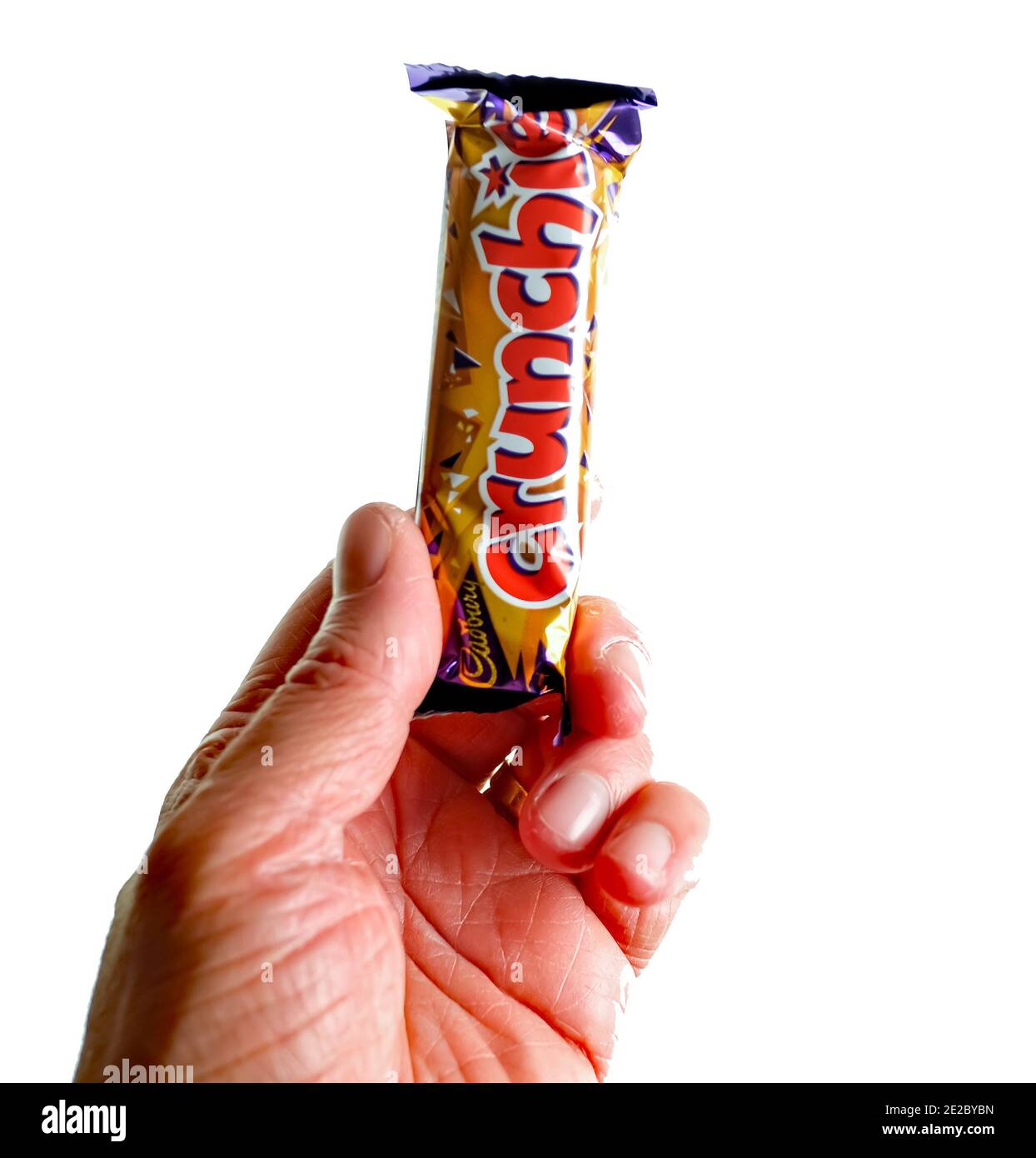 Norwich, Norfolk, UK – December 24 2020. An illustrative editorial photo of an unidentifiable human holding a Cadbury Crunchie chocolate bar Stock Photo
