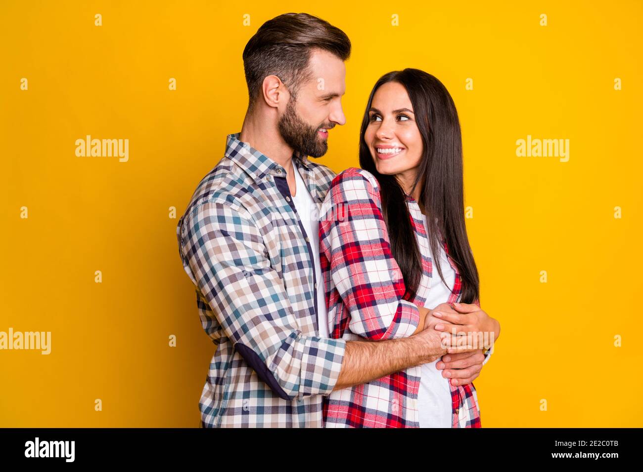 Photo portrait of man hugging woman from behind looking at each other ...