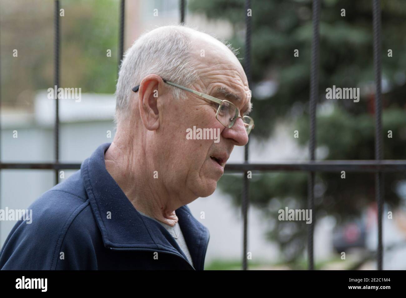 Portrait of an elderly man in profile on the street. The elderly person's face expresses concern and despondency. Close-up. Stock Photo