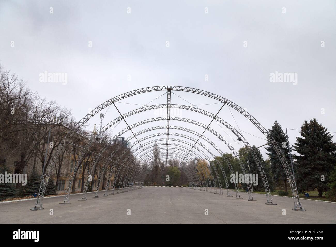 Arched metal frames on the asphalt square. The image shows the central perspective of the arched structure. Stock Photo
