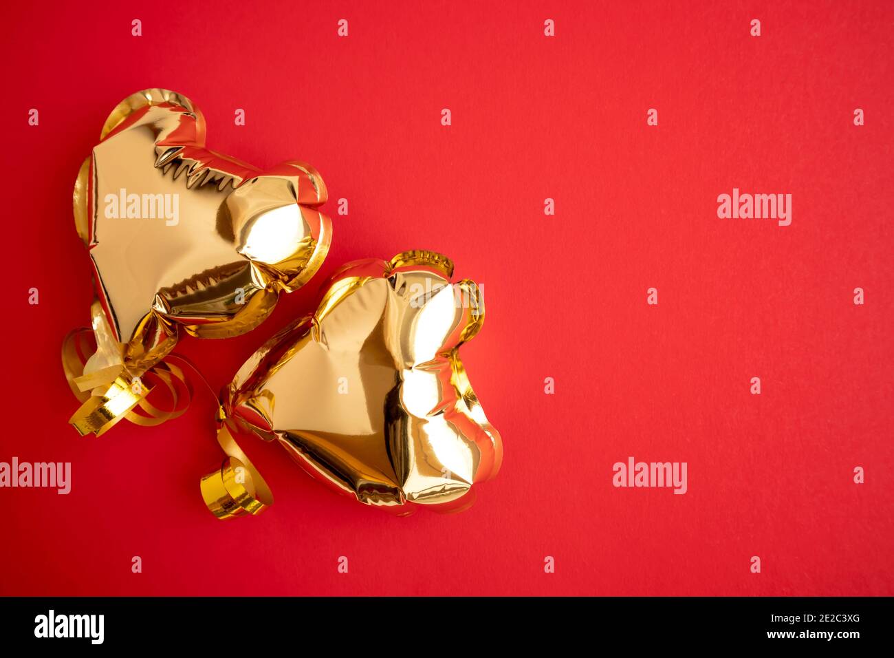 Gold balloons in the shape of a heart on a red background with space ...