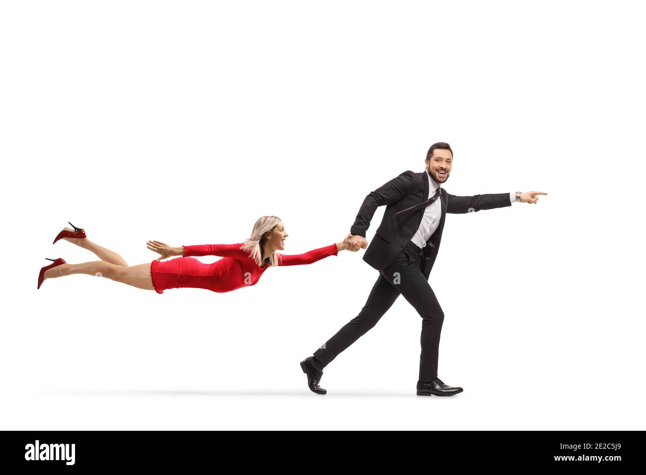 Man in a suit running and pointing and holding a woman in a red dress by her hand isolated on white background Stock Photo
