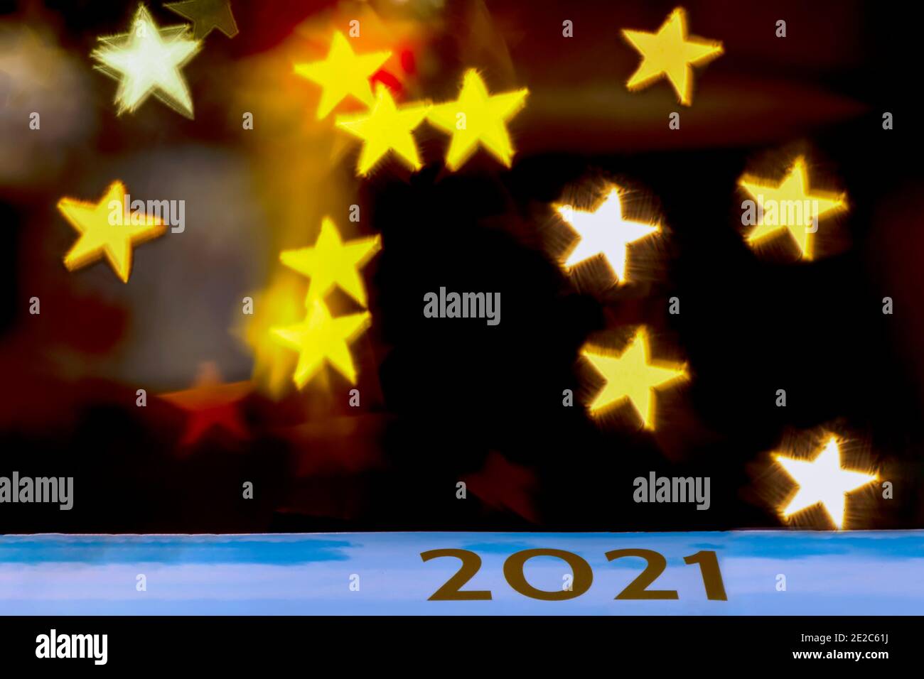 The golden inscription 2021 on a celestial background against a dark background with bokeh of star-shaped lights Stock Photo