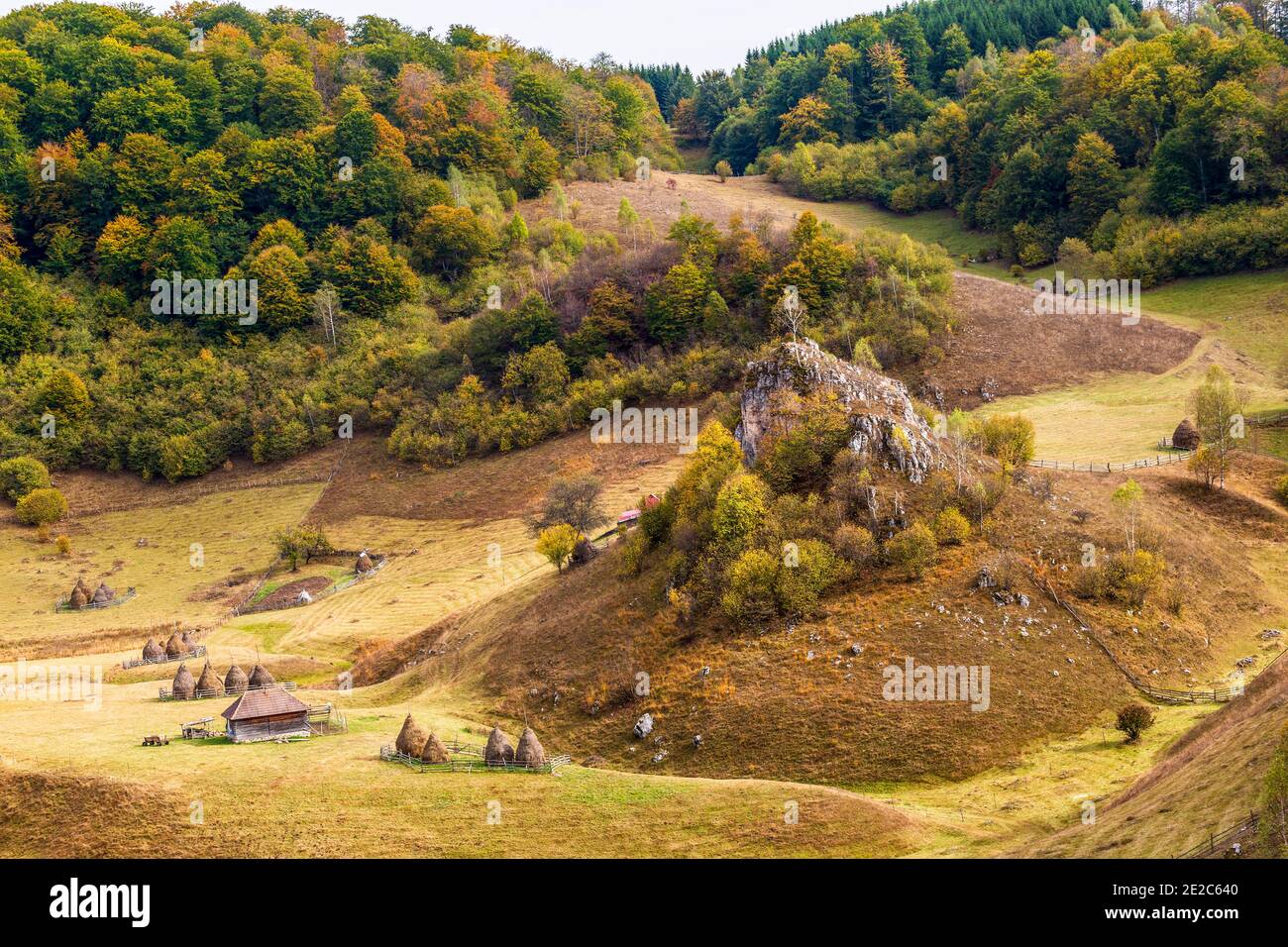 Autumn view of the wolf rock looking down on a small remote mountain village on Fundatura Ponorului. Photo taken on 5th of October 2019 in Fundatura P Stock Photo